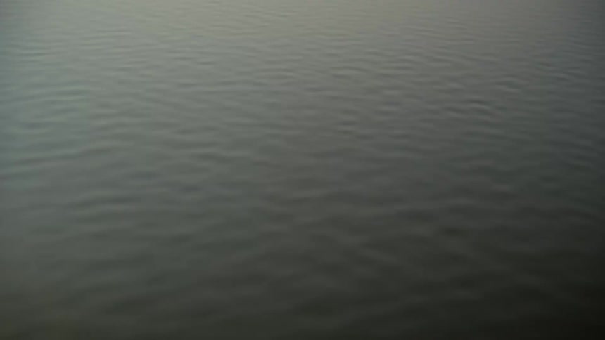 Water surface shows gentle ripples at dusk