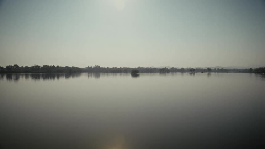 A view of a lake with trees in the distance