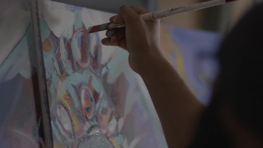 A person paints on a canvas
