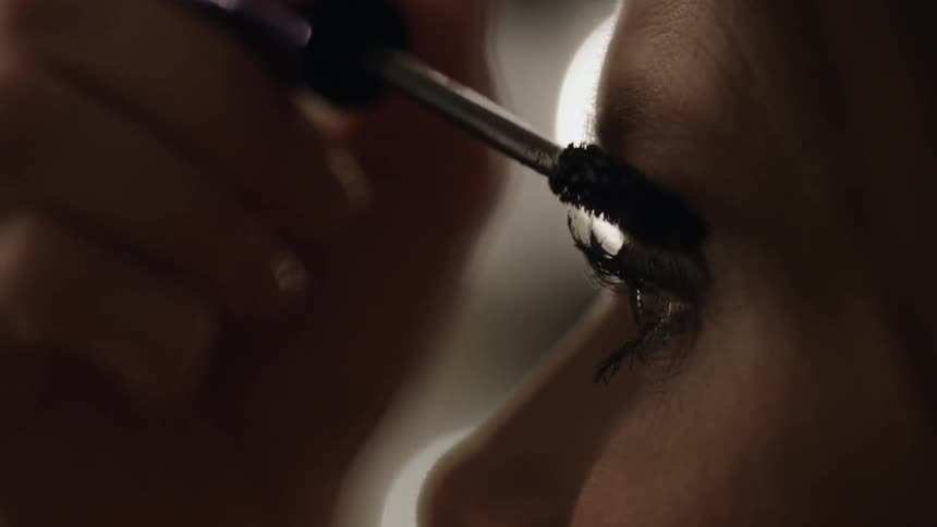 A woman is applying mascara