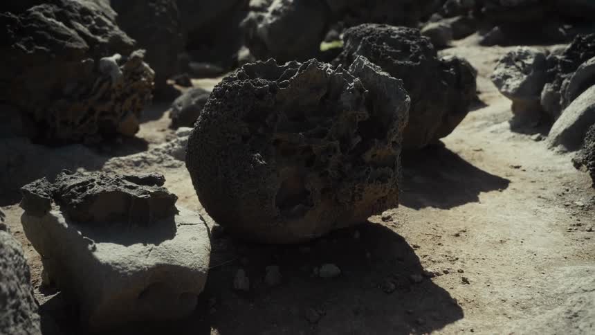 Hag stone next to other stones and pebbles outdoors during day time