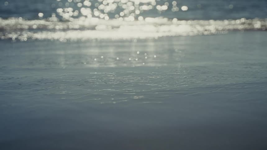 Sea tide next to the beach with the sunlight reflecting on it outdoors during day time