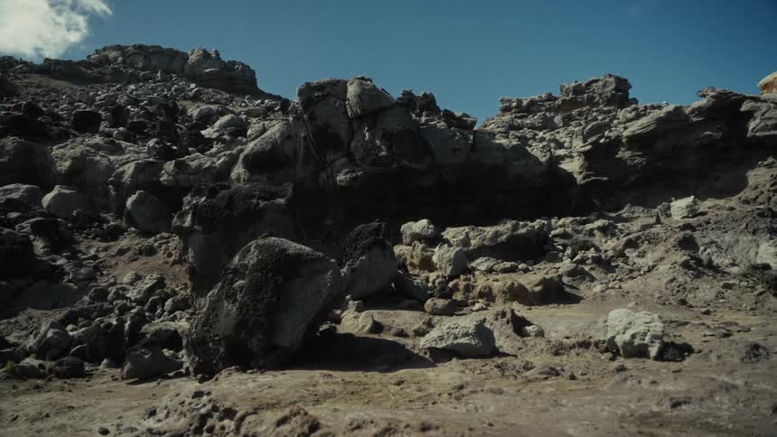 Rocks and boulders on the soil at the foot of rocky mountains