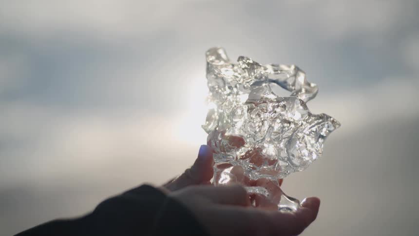 Translucent ice fragment showing texture and refraction under natural light