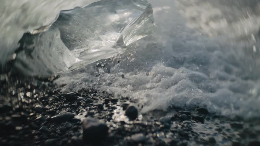 Ice melts on the coast as waves roll in to shore