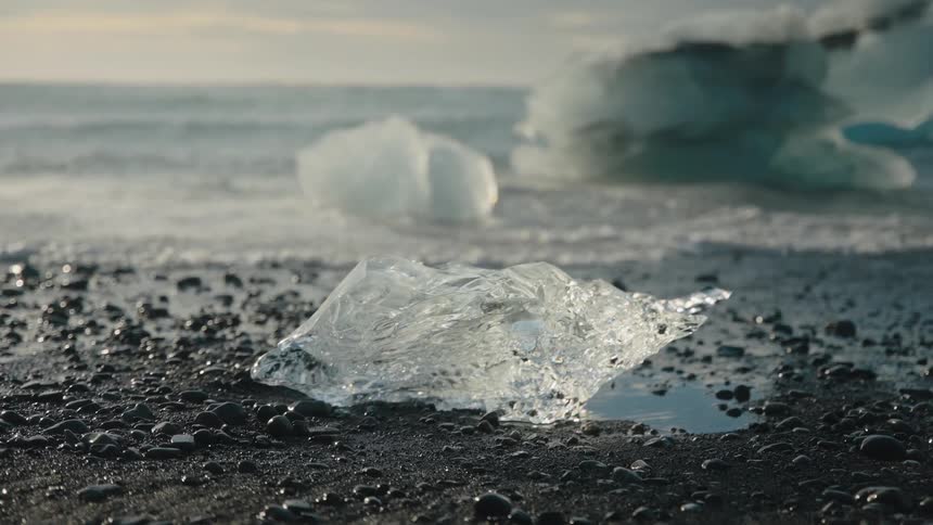 Waves roll into shore as icebergs melt along the coast