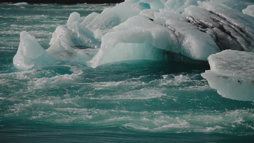Floating icebergs in turquoise water with visible motion