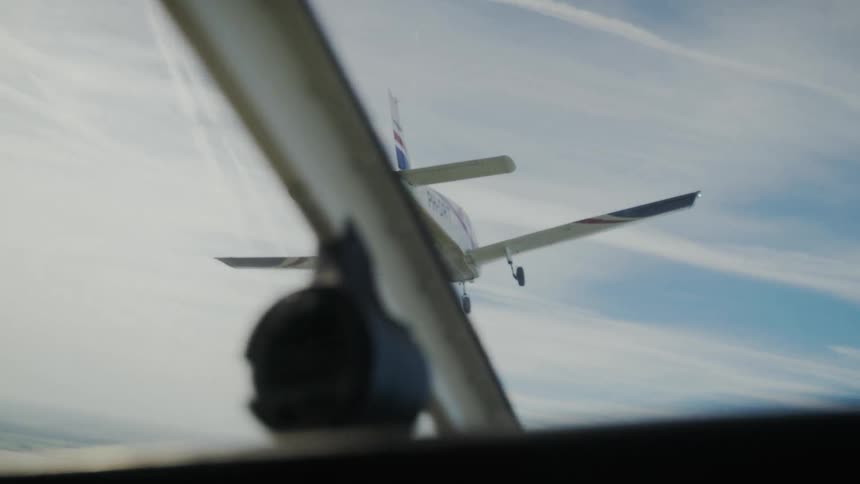 View from inside an aircraft of a small airplane flying ahead