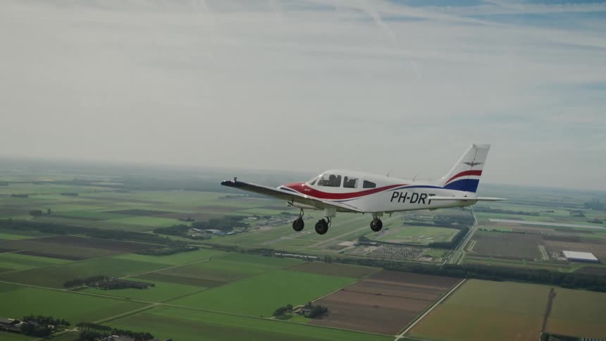 Small airplane flies low over the ground