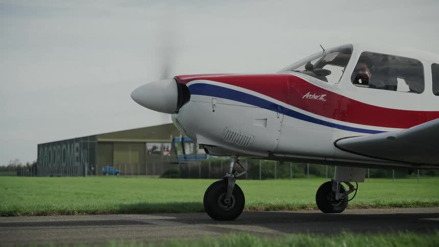 The propeller of a small airplane spins as it prepares to takeoff on a runway