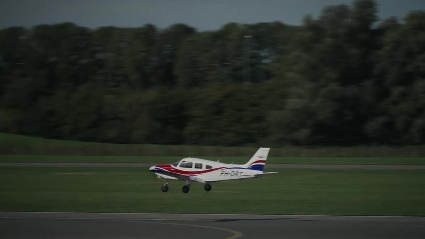 Small airplane comes in for a landing and rolls across the tarmac
