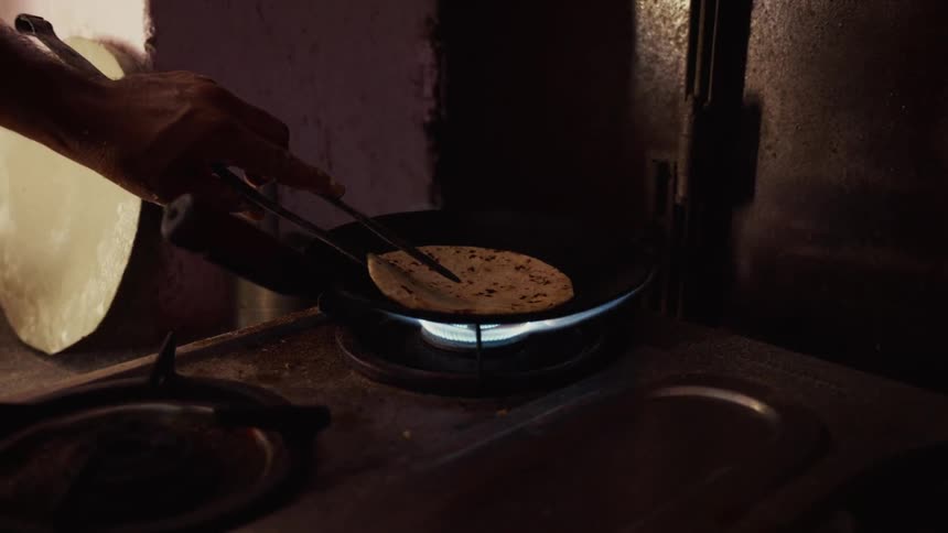 A person cooking bread in a pan