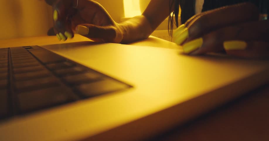 Nail art on a keyboard with golden lighting and a cozy atmosphere