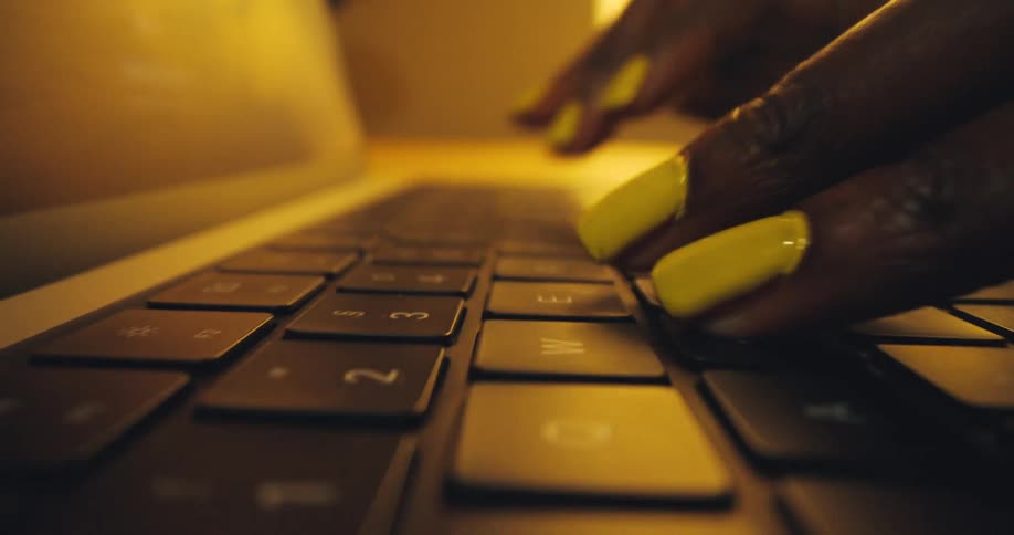 Close up of a woman typing on the keyboard of a laptop computer