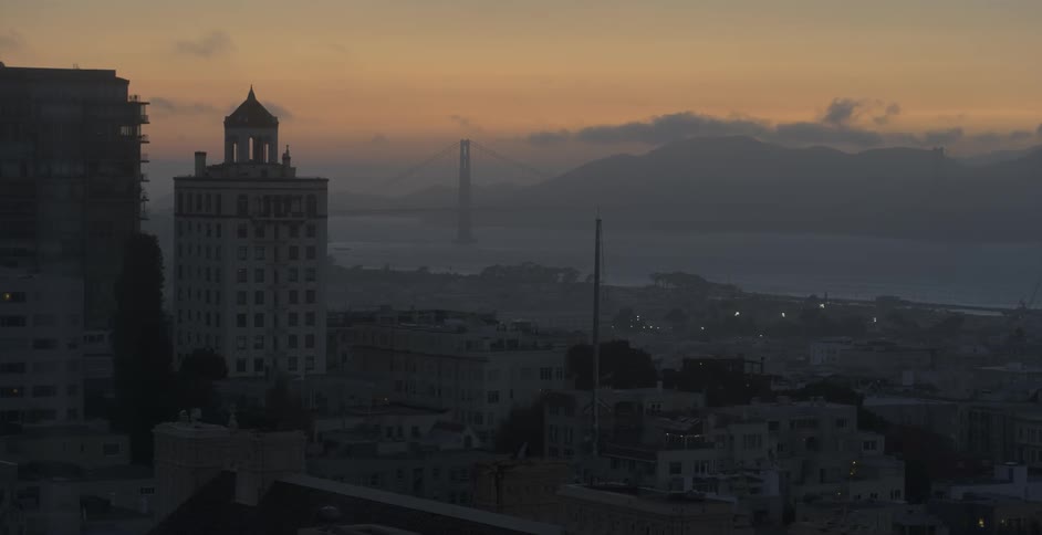 A city at sunset with mountains in the distance