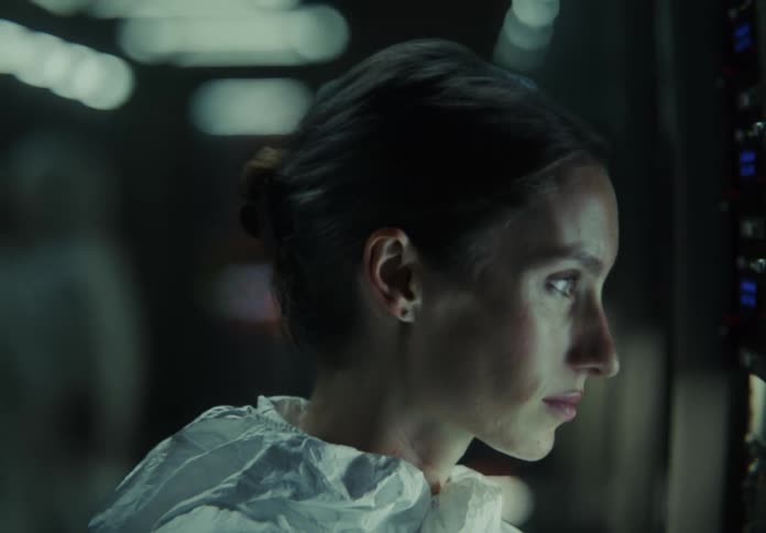 Close-up of a scientist in protective gear analyzing illuminated servers in a high-tech data center