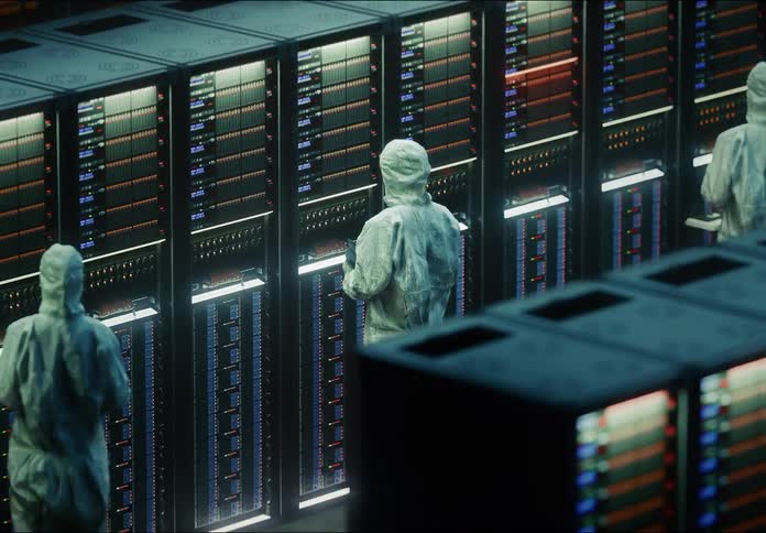 Technicians in cleanroom suits inspecting active servers in hightech data center