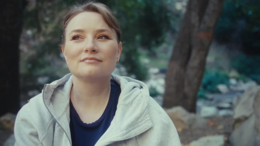 Woman sitting on rock in forest
