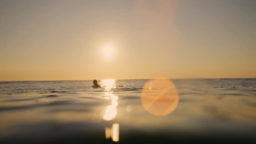 The man floats on his surfboard in the ocean