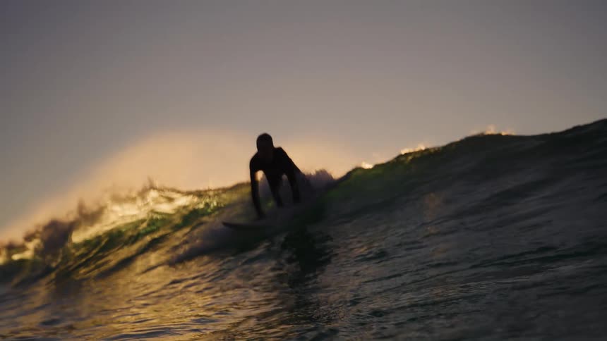 The man rides the wave on his surfboard