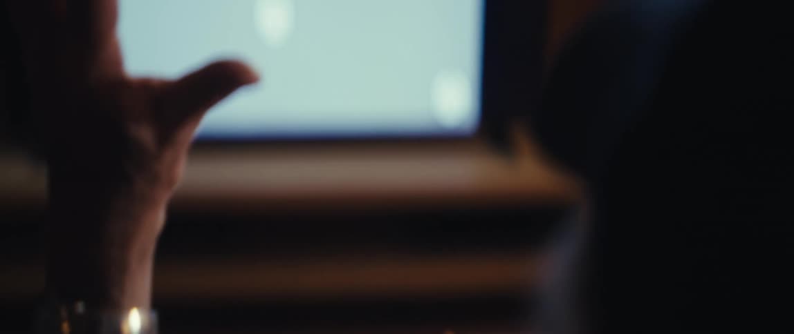 A man sitting in front of a television is clapping and cheering