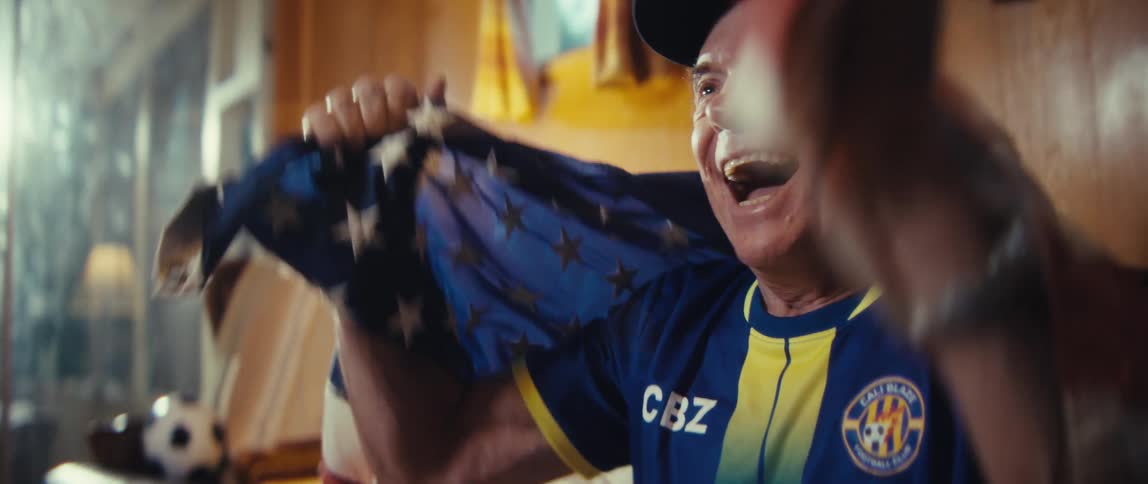 The man cheers at the sports he is watching at home