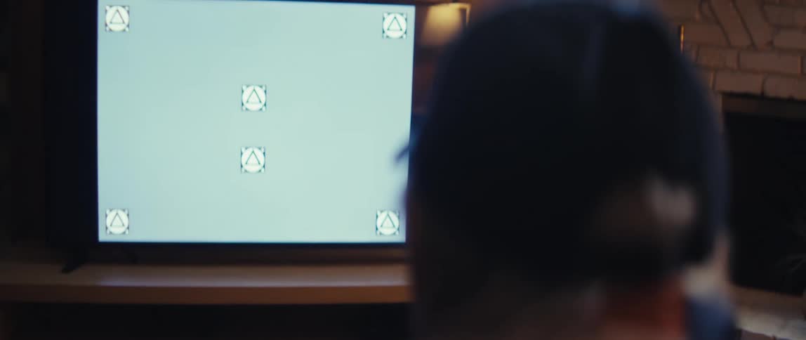 Elderly man clapping his hands while sitting and watching television