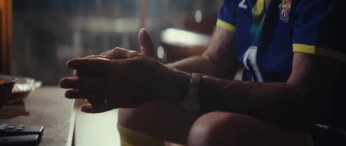 The man is sitting and rubbing his hands together