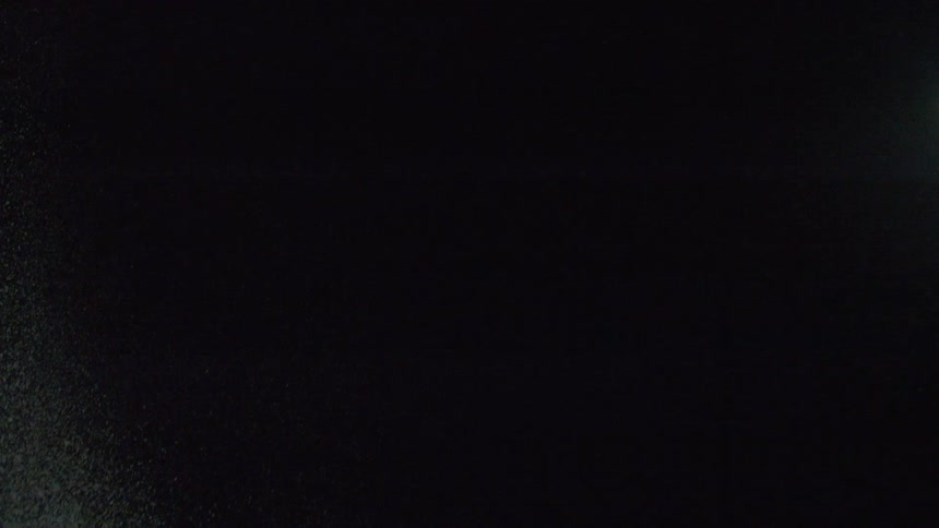 Snow falling from the dark night sky outdoors