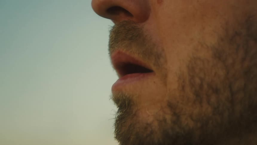 Man smokes a cigarette while looking into the distance