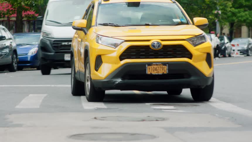 Taxi cab moves in traffic to the side of the road