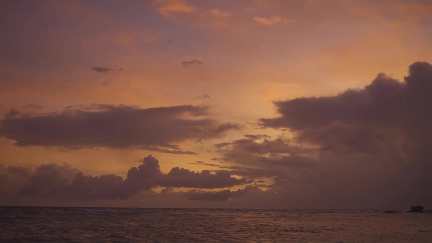 Golden cloudy sky during dusk or dawn over the ocean outdoors