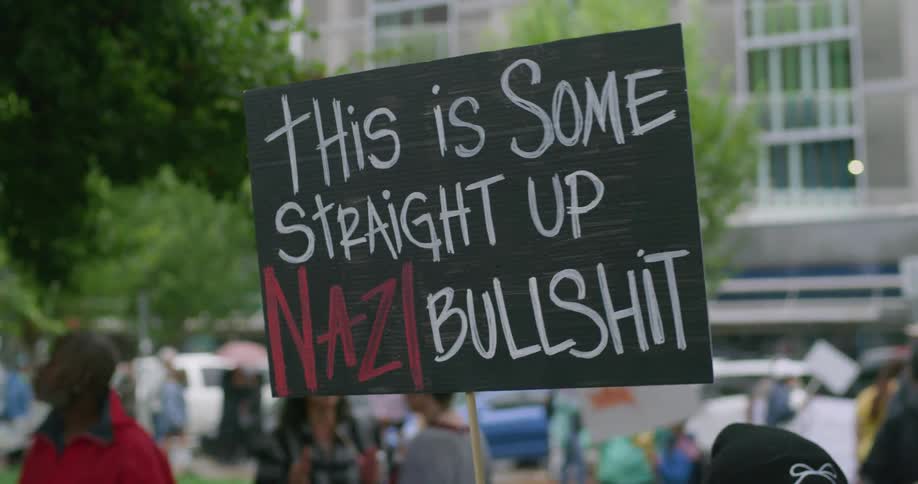 Sign with phrase this is some straight up nazi bullshit displayed during urban protest