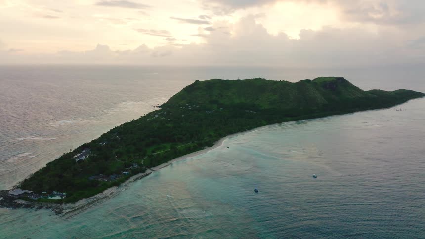 Landscape of an island surrounded by the ocean at sunset