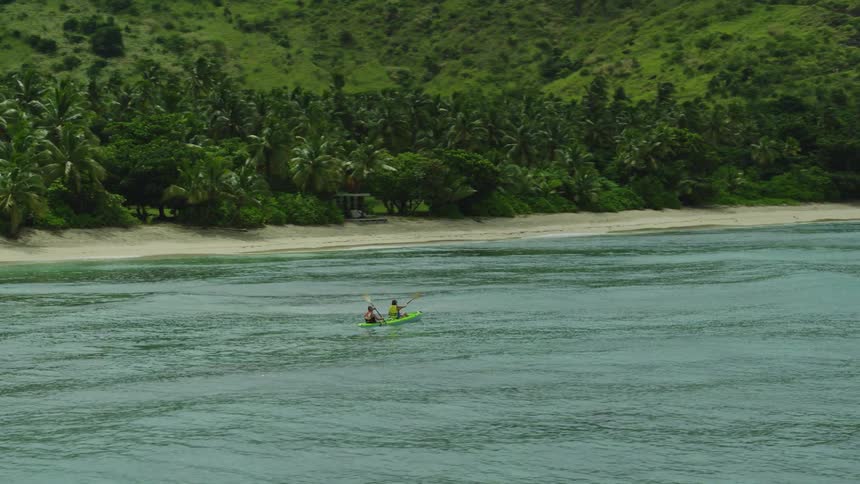 Two people kayaking outdoors on a sunny day