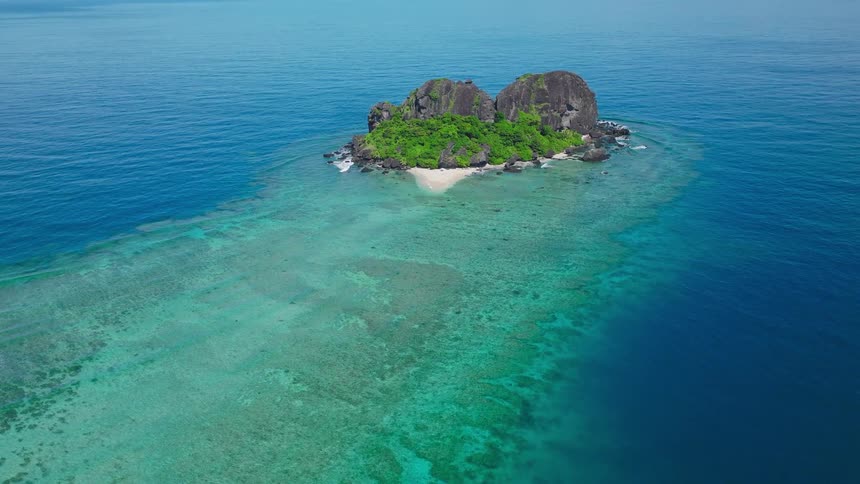 Aerial of a island covered with green vegetation during daytime