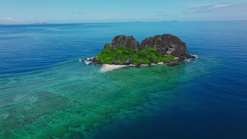 A rocky island in the middle of a blue ocean at daytime