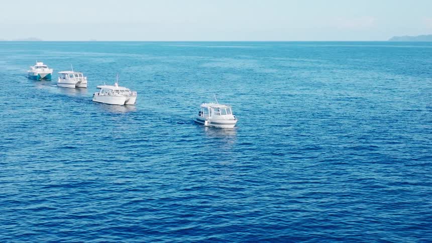 A view of four boats sailing in the ocean