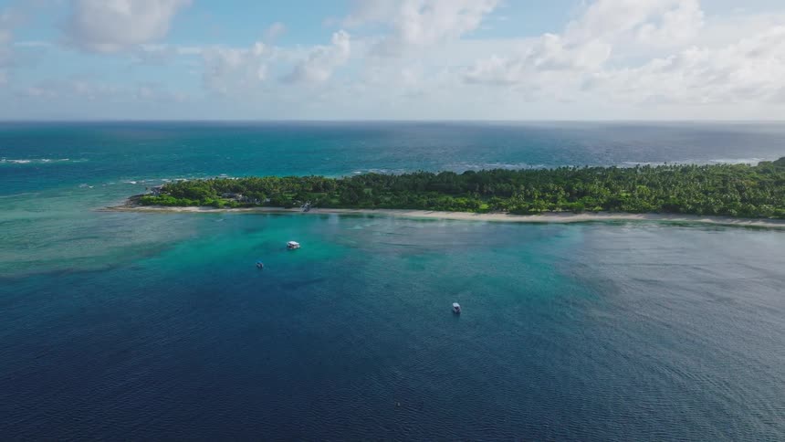 Boats are anchored just off the coast of an island