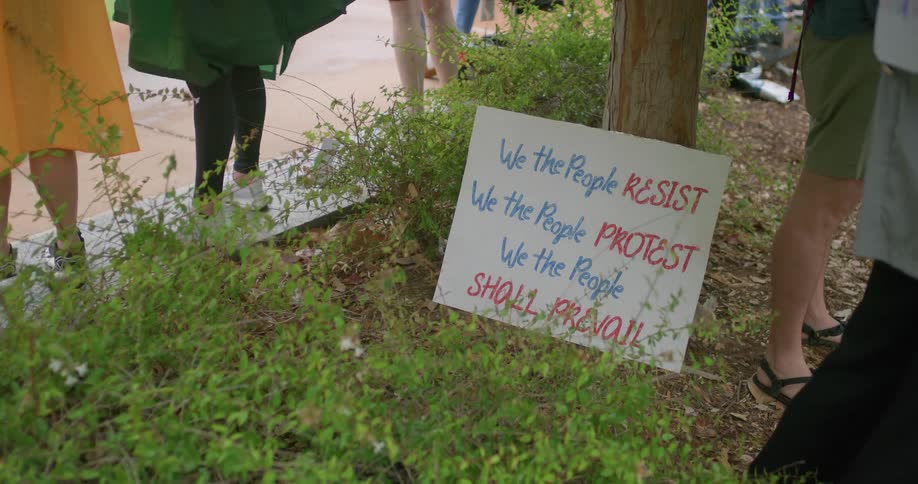 Sign with message against tree during protest