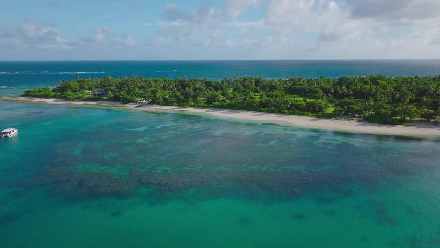 The boat is traveling between small tropical islands