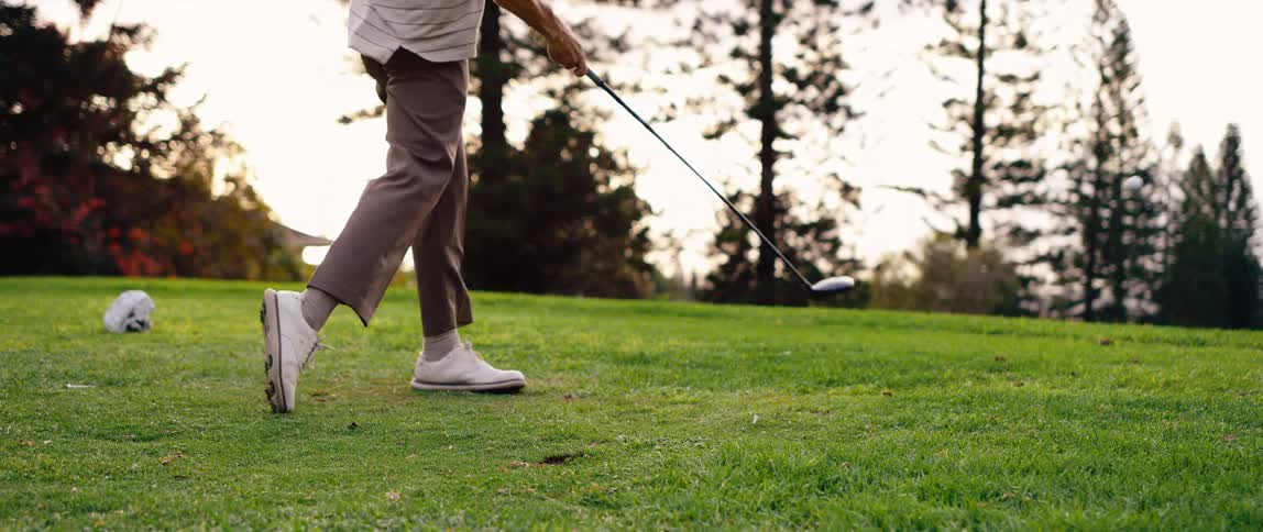 The man swings the golf club on the golf course
