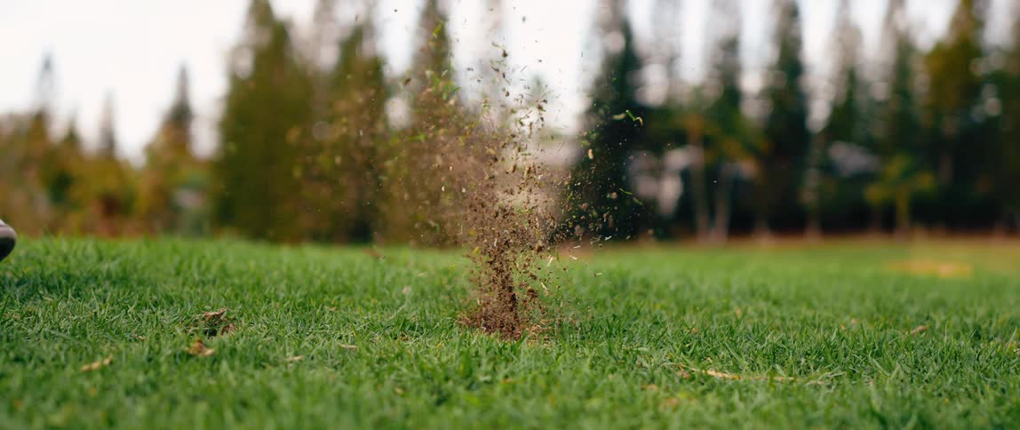 The person drives the golf ball