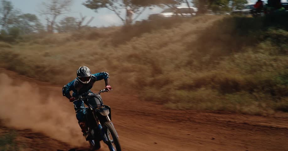 A person with a helmet doing motocross on a dirt road