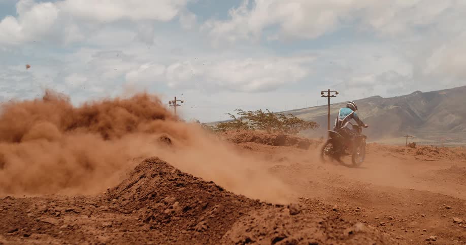 The man speeds off on the dirt bike after making a sharp turn