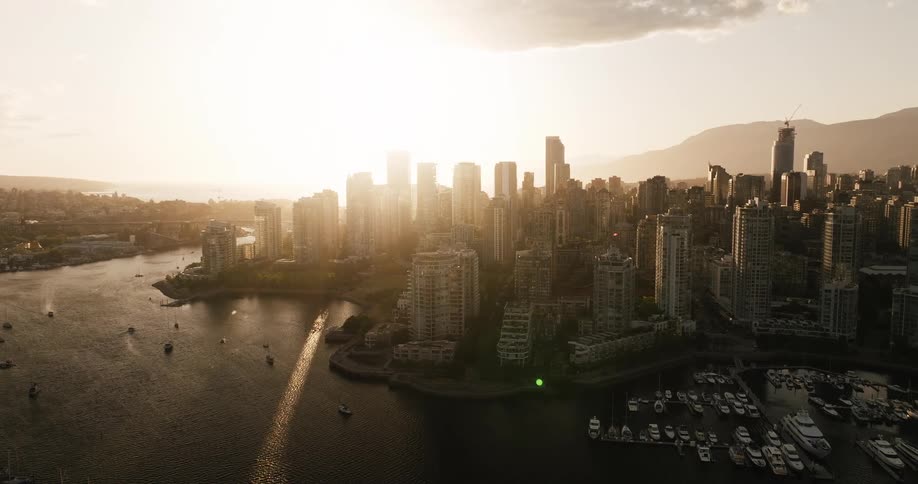 Waterfront buildings and boats on the water in a metropolitan area at sunrise