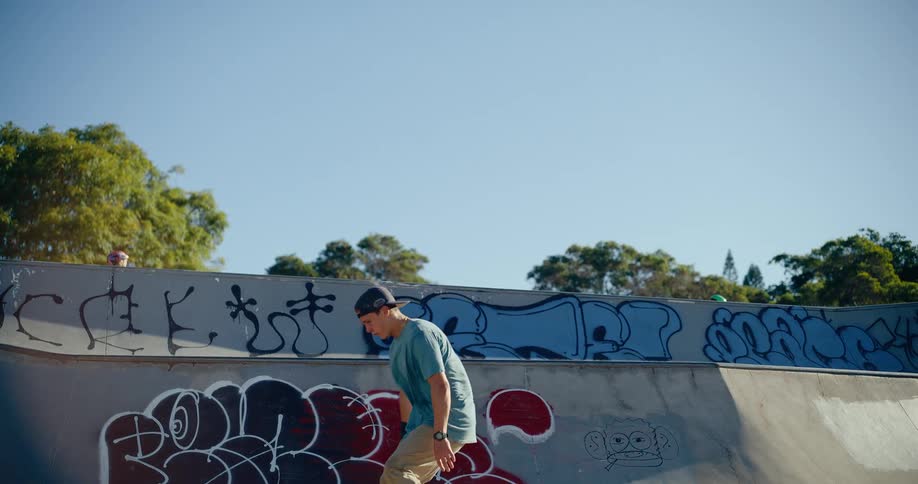 A man is riding a skateboard doing tricks at a skate park