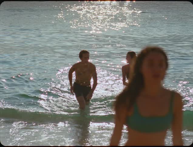 A group of people walks out of the water at a beach
