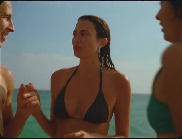 A group of friends standing around on a beach
