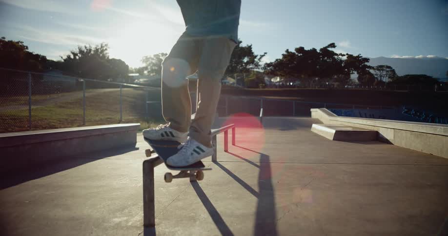 A teenager does a trick on a rail on his skateboard
